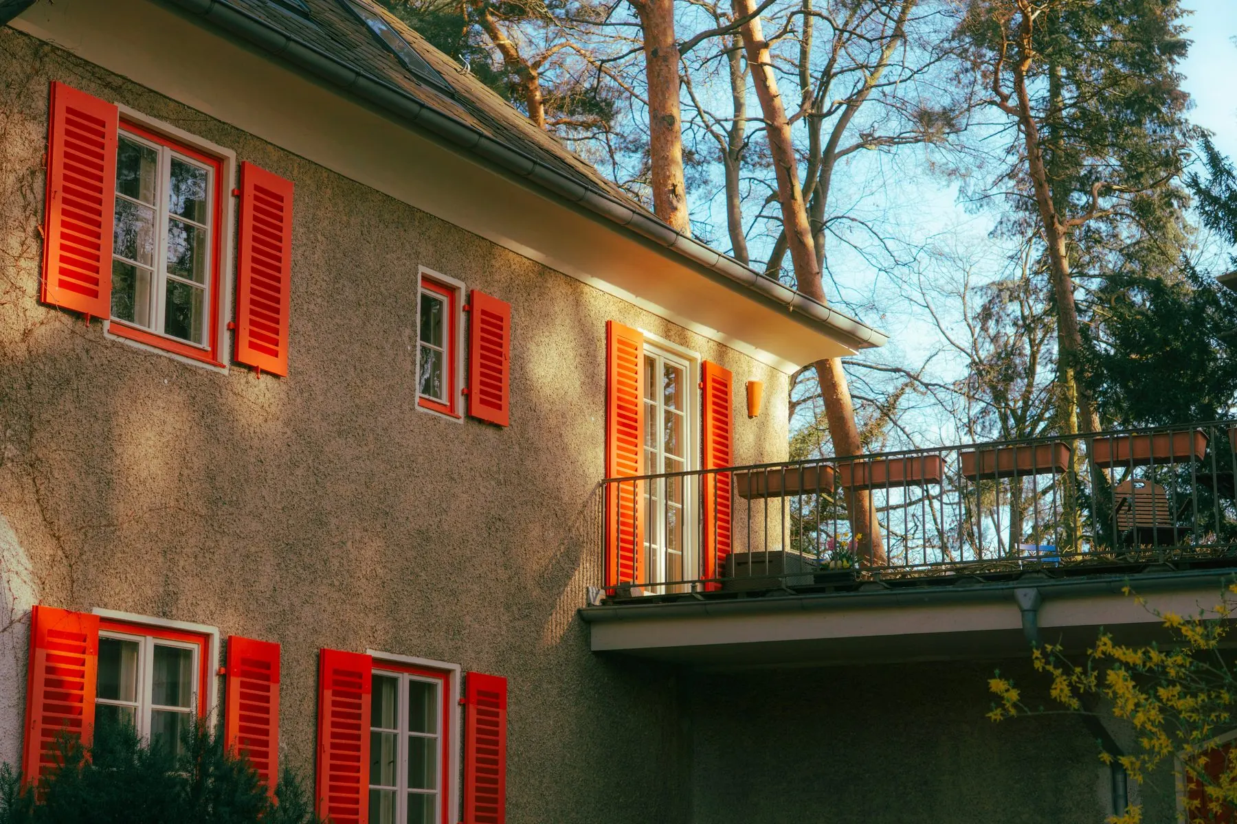 Landhaus mit roten Fensterläden im Abendlicht